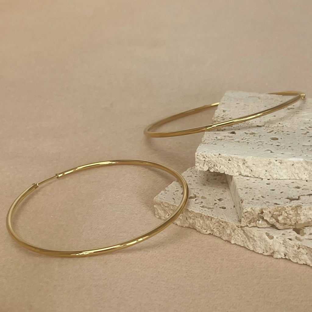 Aros finos dorados sobre piedra